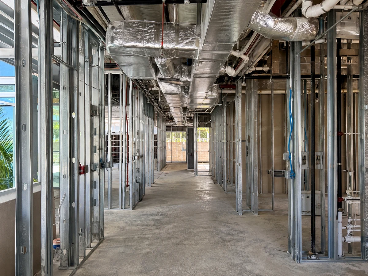 Clear commercial corridor with metal framing, ductwork and exposed building systems