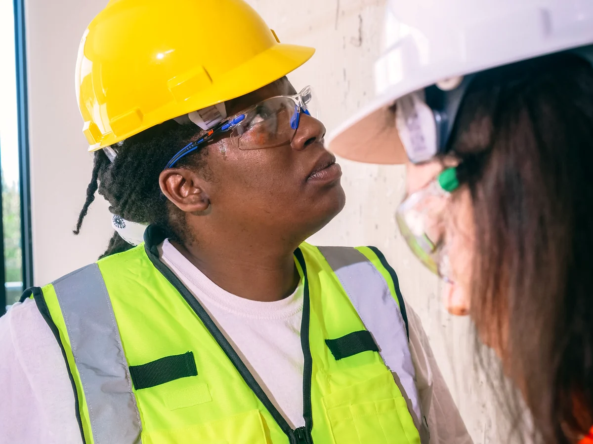 Construction professionals inspecting an existing wall condition and documenting the correction scope