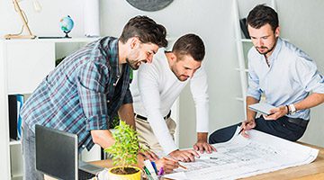 Three men looking at a document