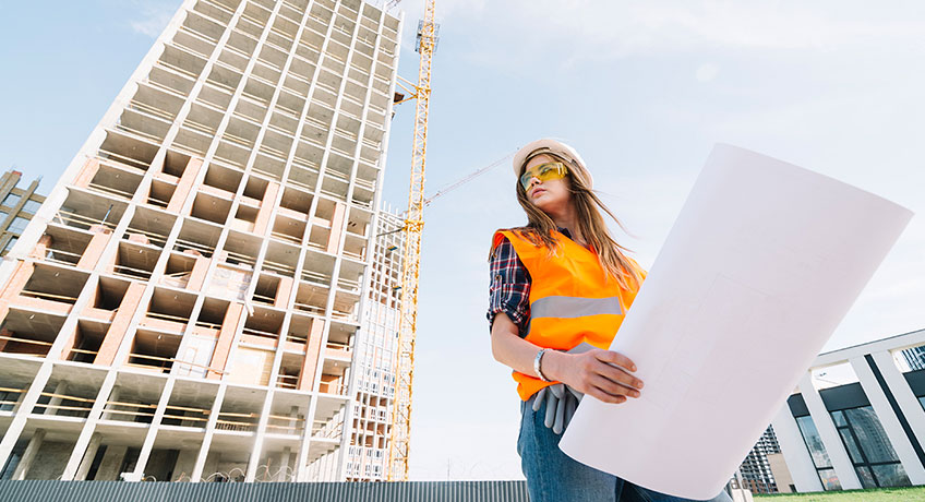 A female construction worker wearing safety glasses