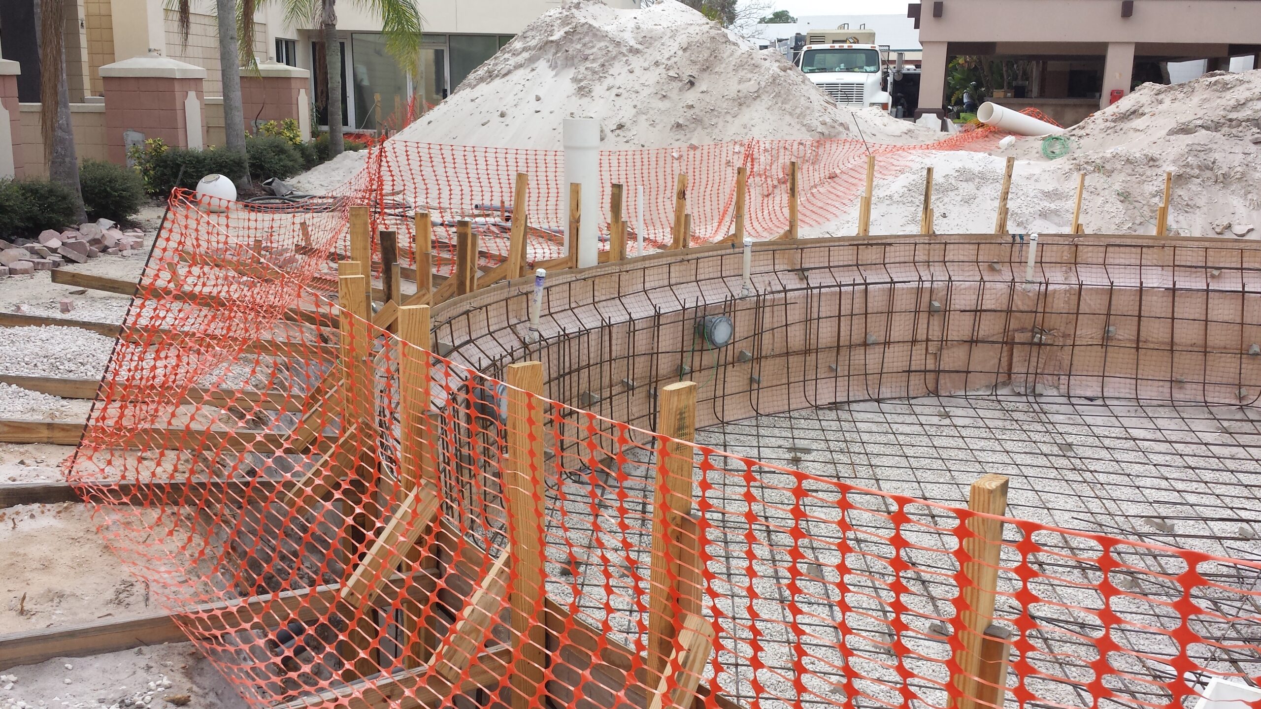 Orange netting surrounding a pool being constructed