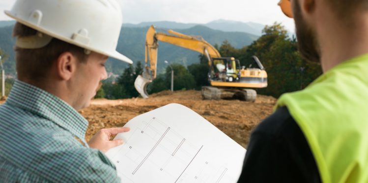 Two general contractors reading construction plans
