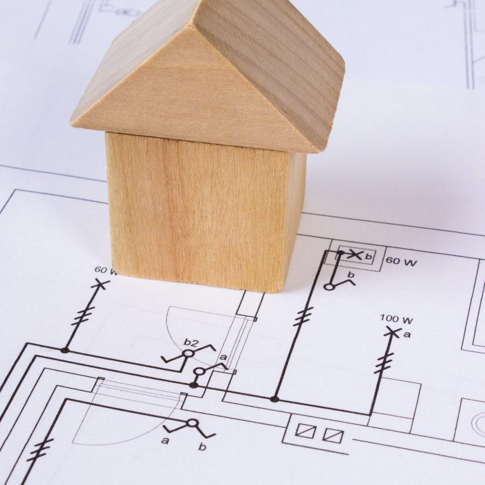 A small wooden house on top of a drawing of a house- best residential contractors near me