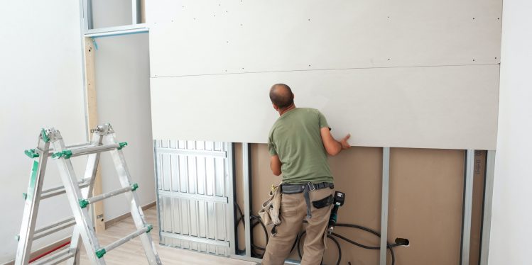 Workers building a plasterboard wall